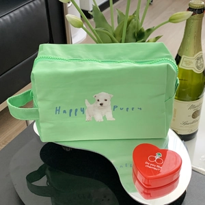 Detail view of mint green puppy makeup bag on a mirror tray with floral accents