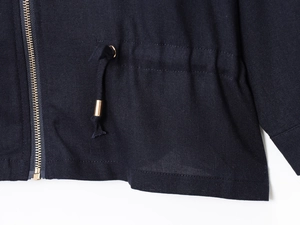 Close-up of navy linen blend jacket with gold zipper and drawstring hardware details