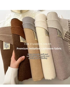 Detailed view of soft cashmere-like scarves with fringe edges in earthy colors