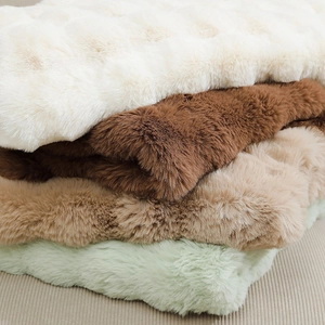 Macro detail showing plush faux rabbit fur texture in cream, brown, and green colors