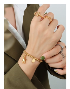Detailaufnahme des Goldperlenarmbands mit Hasenanhänger und stilvollen Ringen