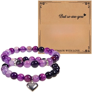 Détail de bracelets en perles de pierre naturelle violette avec breloque cœur sur carte