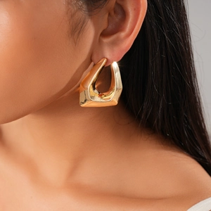 Close-up of 18K gold plated irregular geometric earrings on a model showing metallic luster