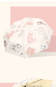 Detail of cream umbrella with cat and strawberry prints showing internal frame structure