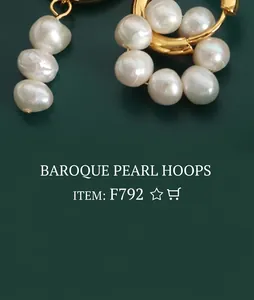 Detail of C-shaped gold-plated hoop earrings featuring white baroque imitation pearls