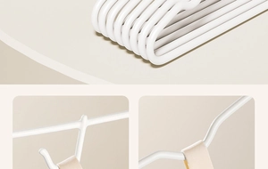 Close-up of white anti-slip hangers showing smooth shoulder contours and stacked design