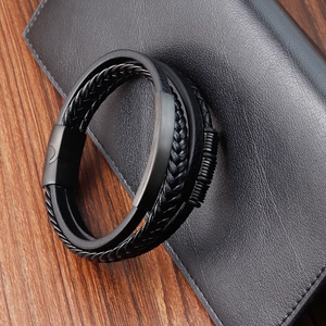 Detailed close-up of multi-layer black leather bracelet with metallic magnetic clasp for men