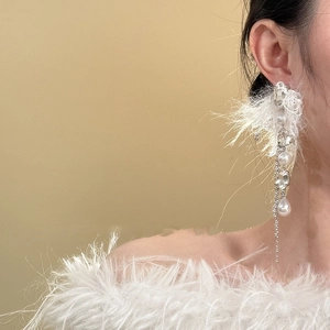 Élégantes boucles d'oreilles argentées avec perles blanches et glands sur modèle