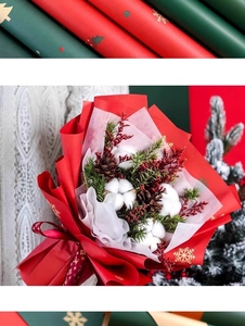 Détail de papier cadeau de Noël rouge avec flocons dorés et bouquet de fleurs