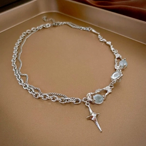 Detailed view of silver star necklace with blue beads on a premium metal tray