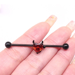 Industrial barbell piercing featuring a black bar with a red heart-shaped devil wing design