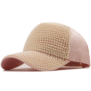 Dettaglio del cappellino rosa in cotone mercerizzato con perle bianche decorative