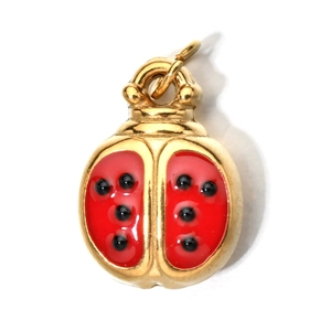 Detailed view of red enamel ladybug charm with gold finish and black polka dots