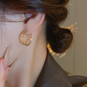 Close-up of gold twist hoop earrings showing vintage texture and elegant metallic finish