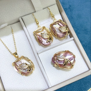 Macro detail of baroque pearl jewelry set with pink pearls in gold leaf settings