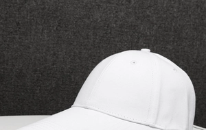 Close-up detail of the white cotton baseball cap showing the stitched crown and top button