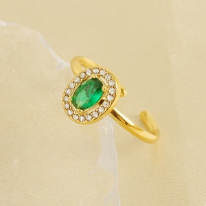 Macro view of 18K gold plated oval green zircon ring on silk background with fine details