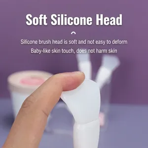 Dual-head silicone face mask brush with flexible fishtail spatula on purple background