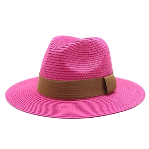 Close-up of a rose red straw Panama hat with fine weave texture and brown band