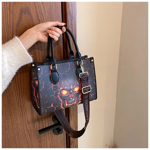 Detail view of large skull tote bag with red flame pattern and wide crossbody strap