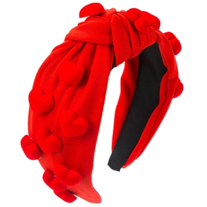 Detail of red knotted headband with 3D velvet heart accents and knitting texture