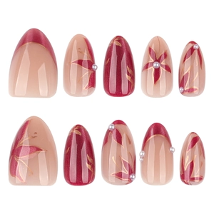 Faux ongles amande courts avec motifs floraux rouges, bords dorés et perles