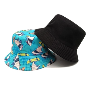 Reversible bucket hat with cartoon shark pattern and solid black cotton canvas design