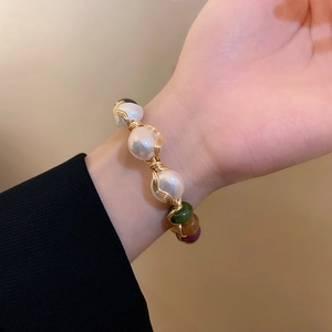 Detailed view of handmade gold wire-wrapped bracelet with baroque pearls and colorful beads