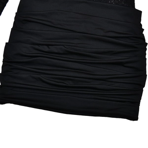 Gros plan d'une robe moulante noire avec des plis horizontaux et une texture de tissu