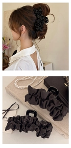 Détail d'une élégante pince à cheveux en satin plissé noir avec des accents de cristaux