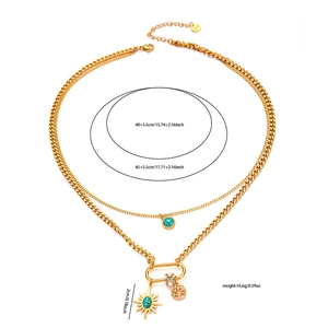 Dettaglio della collana dorata a due strati con ciondoli a sole e albero della vita