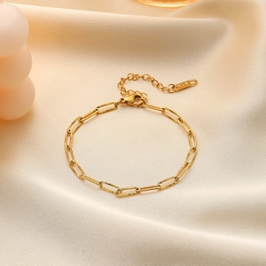 Elegant gold paperclip chain necklace with striped texture on soft silk background