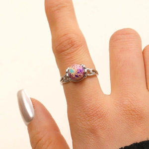Detailaufnahme eines silbernen Boho-Rings mit buntem Edelstein am Finger