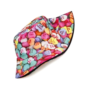 Dettaglio della stampa con cuori e caramelle sul cappello a secchiello reversibile