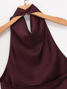 Close-up of wine red satin halter top with glossy silk texture on wooden hanger