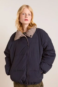 Detail of the vintage quilted navy blue jacket featuring a classic plaid collar contrast