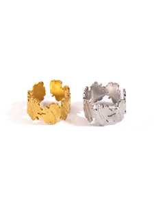 Detailed view of adjustable stainless steel rings with layered leaf texture in gold and silver