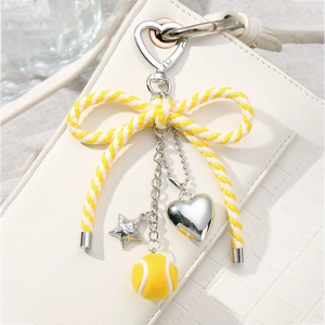 Handmade woven bow keychain with silver heart and star charms plus yellow plush tennis ball