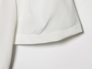 Dettaglio delle cuciture e della trama del tessuto sull'orlo del vestito bianco