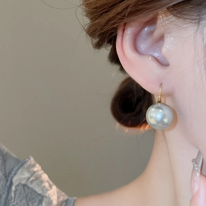 Close-up of grey metallic pearl drop earring with 18K gold hook on a female model