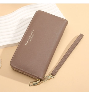 Detail of a brown textured leather long wallet with wristlet and gold zipper closure