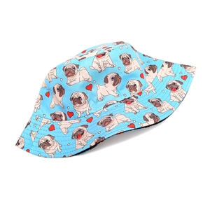 Close-up of light blue bucket hat featuring cartoon pug dogs and red heart prints