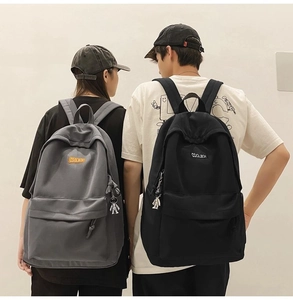 Detail of the high-capacity backpack featuring the brand logo and cute astronaut pendant