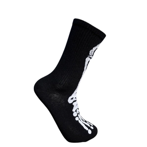 Détail d'une chaussette noire en coton avec motif graphique d'os de pied de squelette