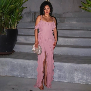 Detail of pink backless maxi dress with ruffle accents and side slit paired with silver clutch