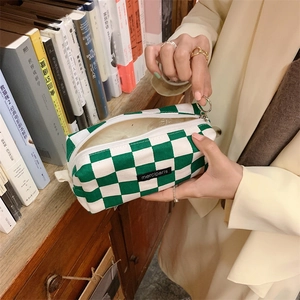 Primer plano detallado del estuche de lona a cuadros verdes con etiqueta merciparis