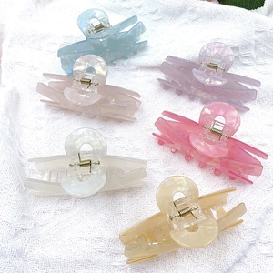 Pastel marble acrylic hair claws in multiple colors on white lace fabric backdrop