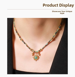Detail of beaded necklace with sun pendant and turquoise stone on a black V-neck top
