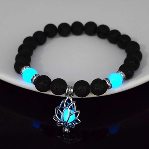 Close-up of luminous lotus bracelet with black lava stone beads glowing in the dark