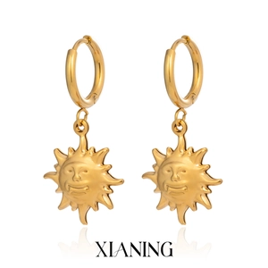 Detailed view of sun smiley face pendant earrings in 18K gold plated stainless steel